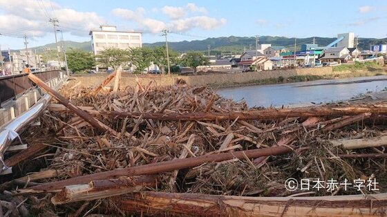 大雨で増水した河川に押し寄せた流木