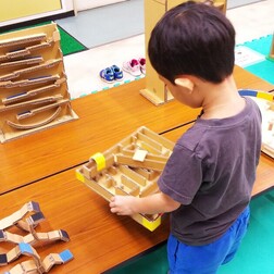 写真:ビー玉迷路で遊ぶ子ども